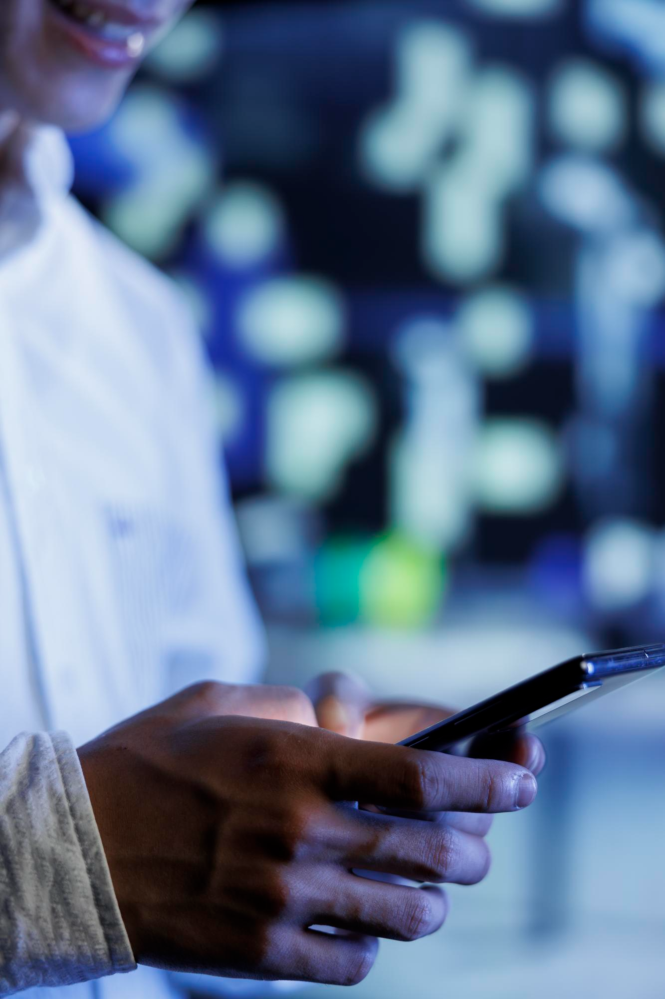 Subscriber checking a mobile phone with city lights glowing in the background