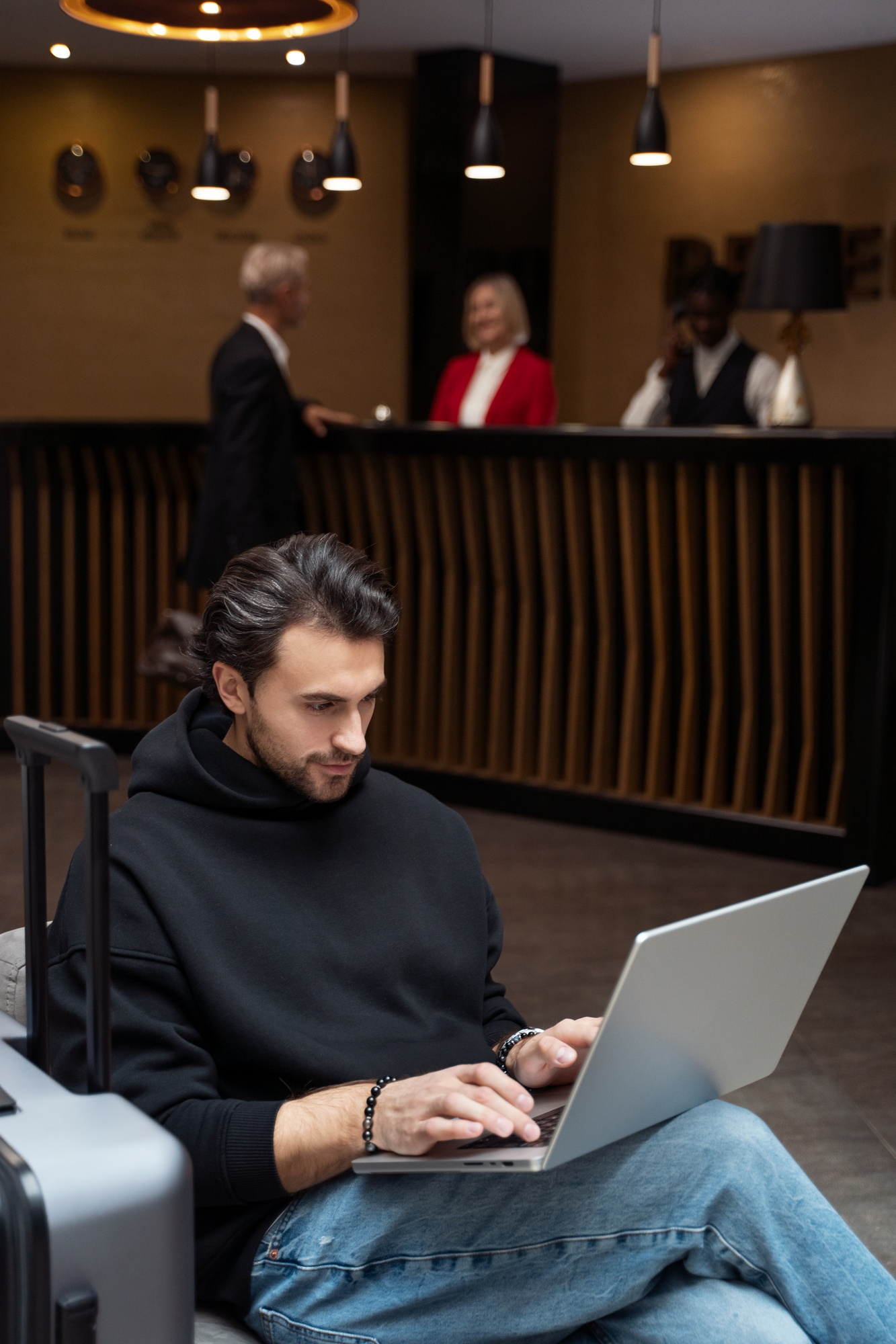 Guest working on a laptop in a hotel lobby near the reception desk